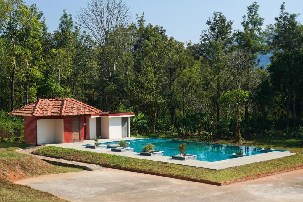 瓦亚纳德Zostel Homes Wayanad, Thirunelly的庭院中带游泳池的房子