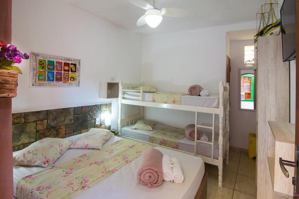 帕拉蒂Pousada Casa do Rio Hostel - 8 min do Centro Hístorico - Passeio de Barco com saída da Pousada -Pago a parte- Perto das Praias e Beira Rio的一间卧室配有两张双层床,带两个婴儿