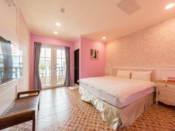 南湾靓南湾包栋民宿的卧室配有一张大床,位于带粉红色墙壁的房间