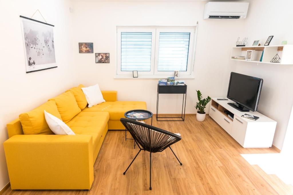 采列Apartment ALMA - to travel is to live的客厅设有黄色沙发和电视