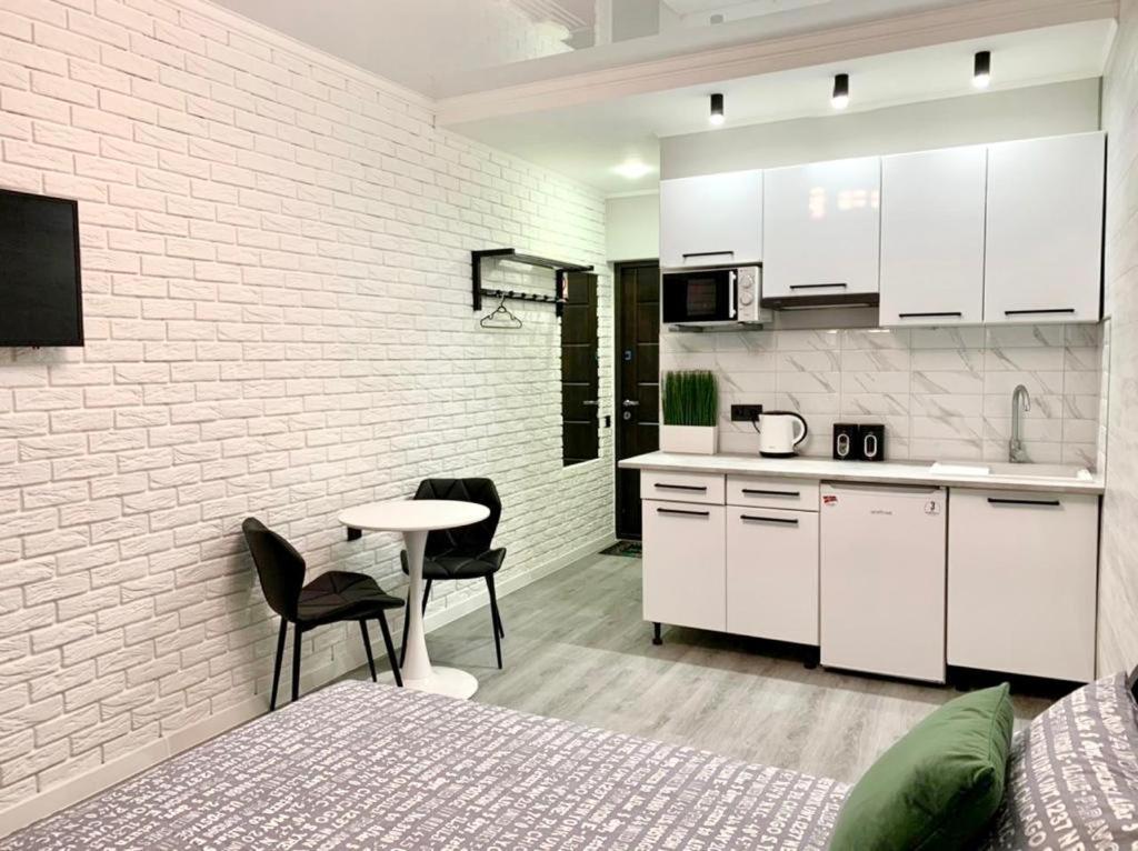 伊尔平Green room в ЖК Рич Таун Ирпень的厨房配有白色橱柜和桌椅