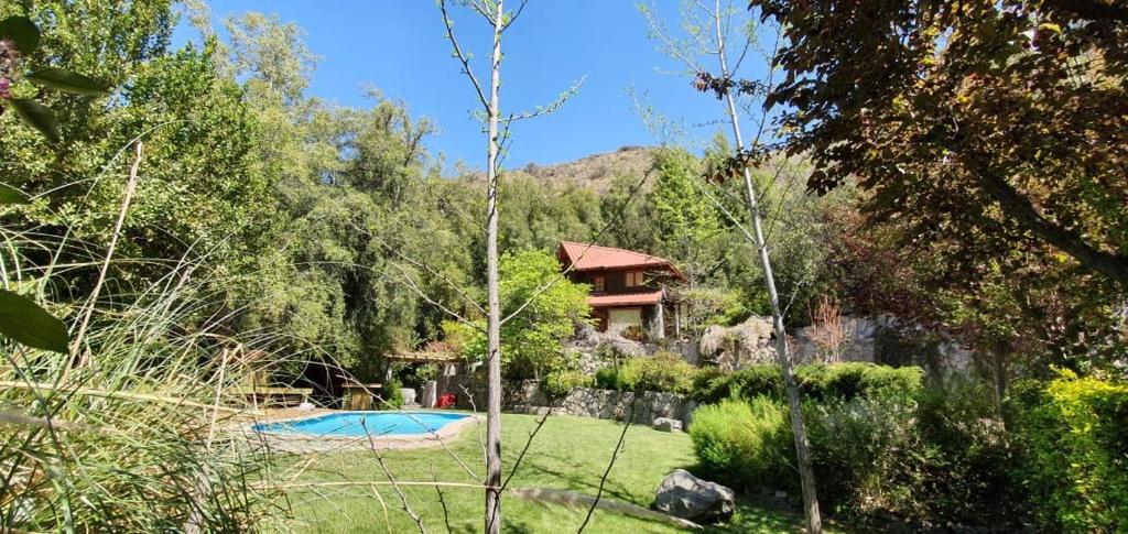 圣何塞德迈波Casa de Montaña inmersa en Bosque Nativo的一个带房子和游泳池的花园