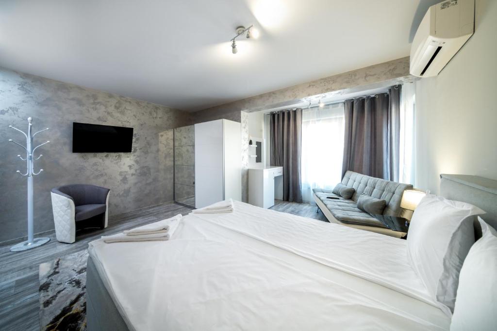 布尔加斯Boutique Guest House"Ruvan"的酒店客房设有一张大床和一张沙发。