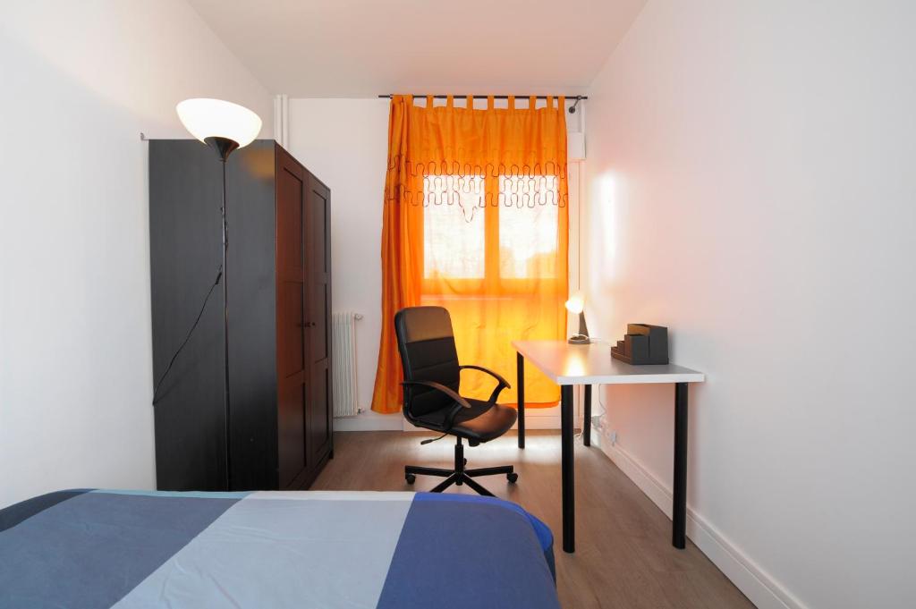新城拉加雷讷Charmant 2 pièces proche de Paris的一间卧室配有一张床、一张桌子和一把椅子