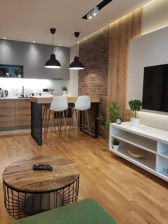 诺维萨德Tesla 3 Apartment的厨房以及带桌子和电视的客厅。