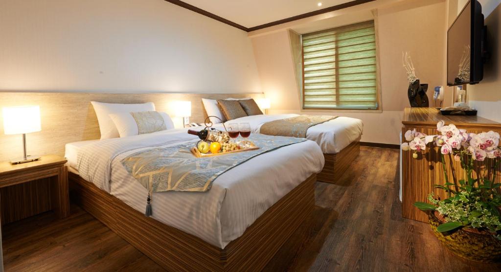 济州市四季酒店的酒店客房,配有两张床,上面有水果盘