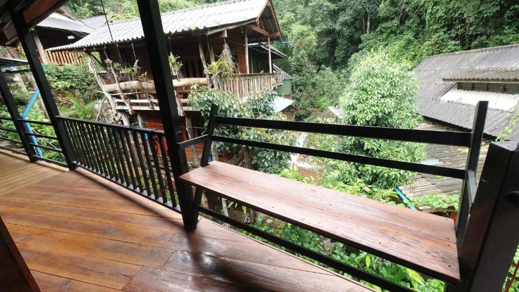 Ban Pok Naiไชยพล โฮมสเตย์ หมู่บ้านแม่กำปอง的甲板上设有木门廊和长凳