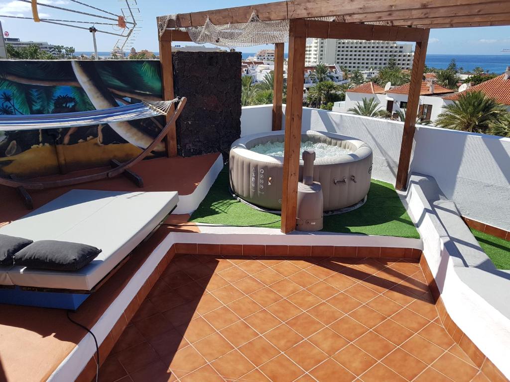 阿罗纳Chill out Apartment Tenerife的一个带热水浴缸和秋千的庭院