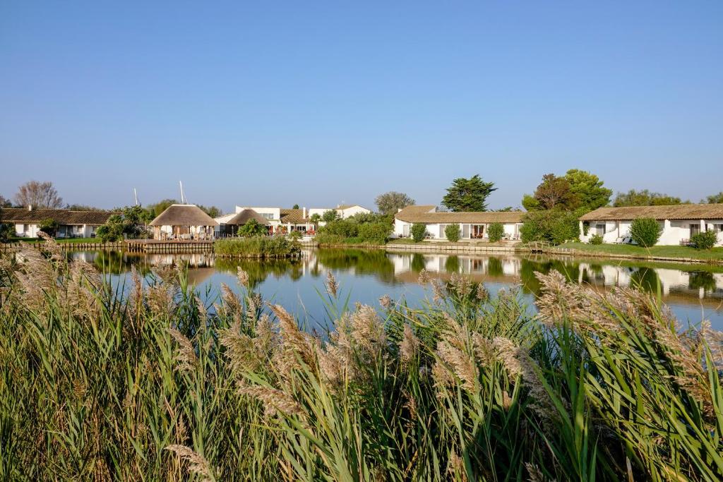 圣马迪拉莫埃斯特尔恩卡马格酒店的享有带房屋和草地的湖泊美景