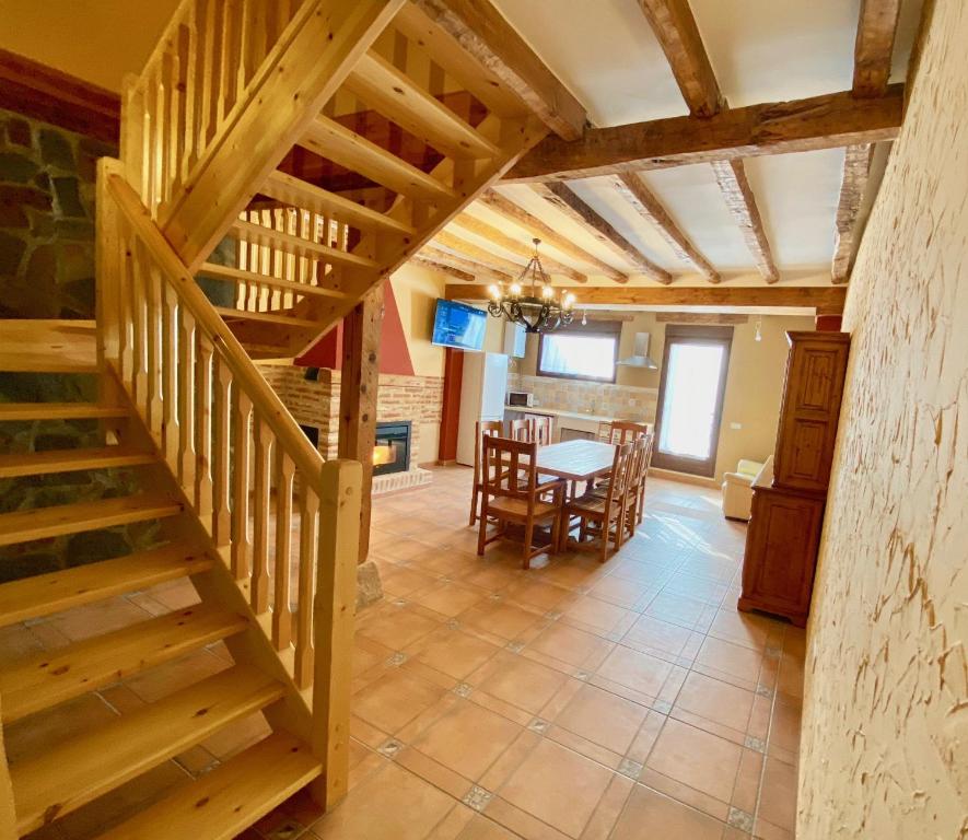 鲁埃达La Parada de Jimena-Casa rústica rodeada de bodegas en Rueda的客厅里木楼梯,配有桌子