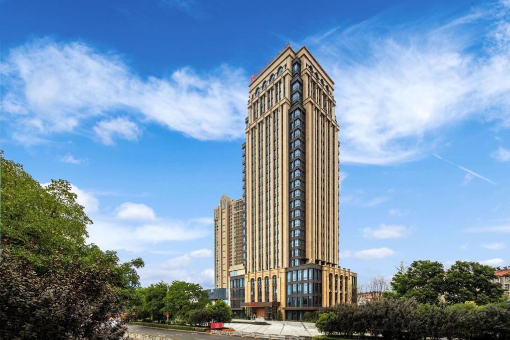 武汉武汉黄陂华美达广场酒店的一座高大的建筑,旁边是钟