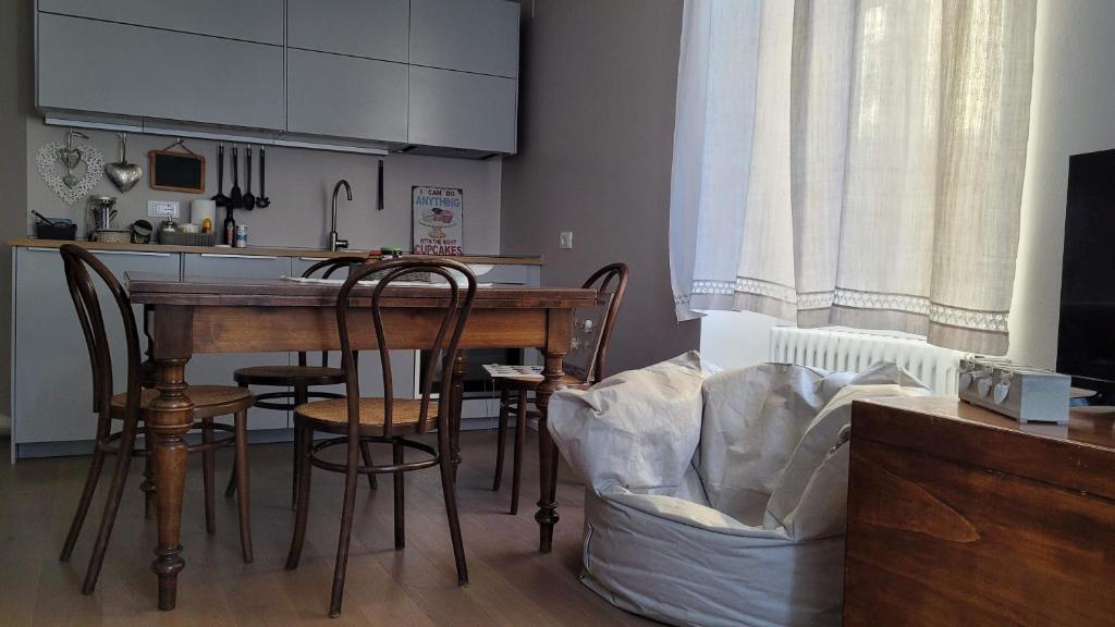 罗韦雷托Lo Scricciolo的一间带木桌和椅子的厨房和一间带白色橱柜的厨房