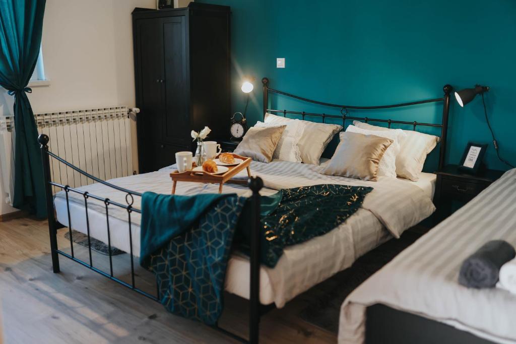 Lički OsikApartman Hana的一间卧室设有两张蓝色墙壁的床。
