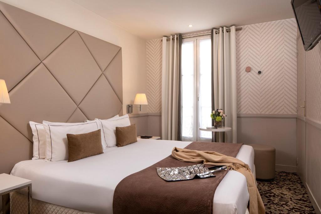 巴黎郎香爱丽舍酒店的酒店客房设有一张白色大床和一个窗户。