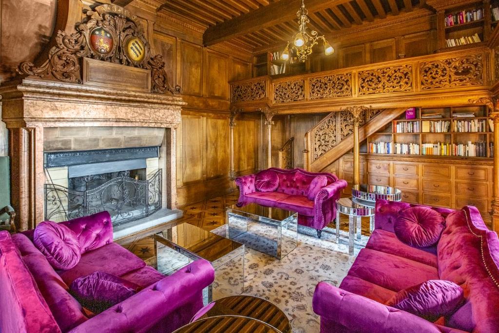 ClarensAntique apartment in the XV century Castle的客厅配有紫色沙发和壁炉