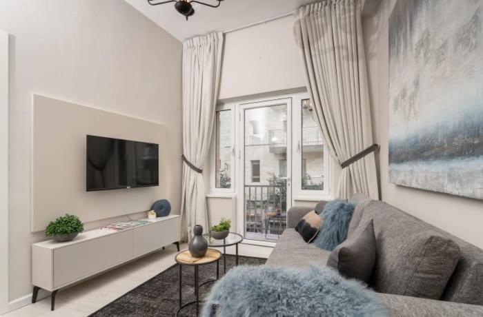 耶路撒冷Ben Yehuda, 3 Lovely Flats in the same building的带沙发和电视的客厅
