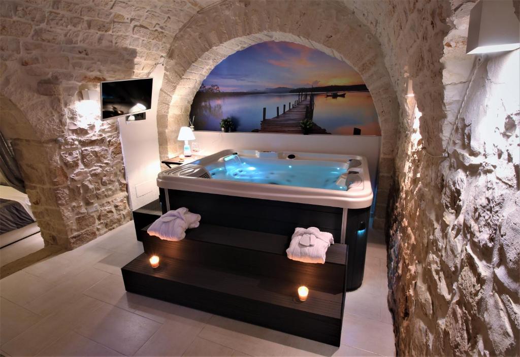 图里Albergo Diffuso Dimora Rossi的一间石墙内带浴缸的浴室