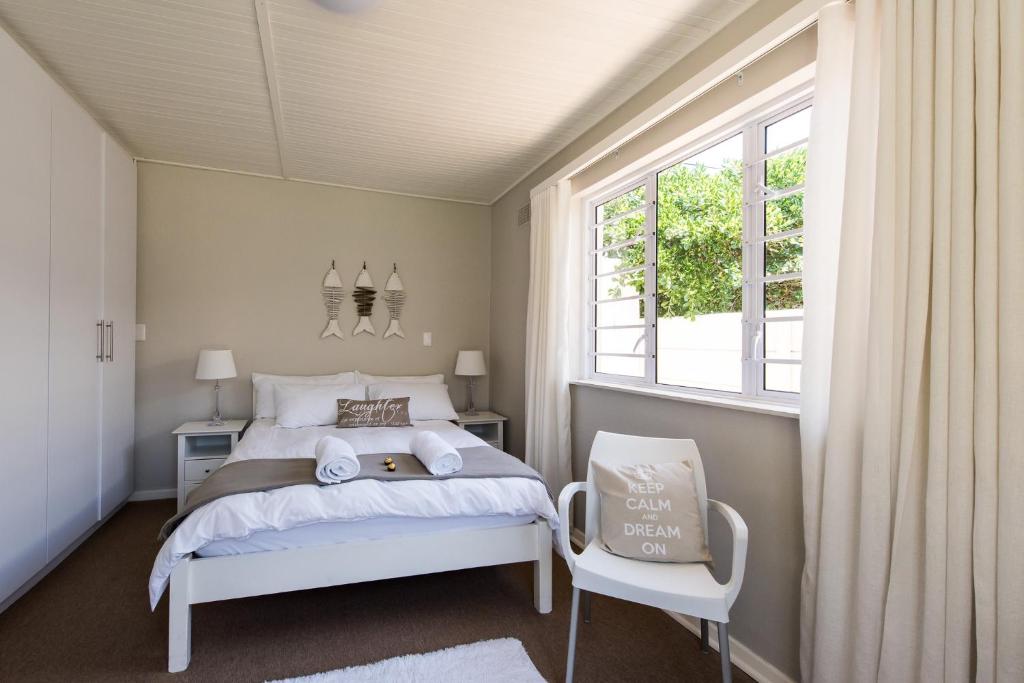 梅尔克博斯特兰Melkbos Holiday Accommodation的卧室配有白色的床和窗户。