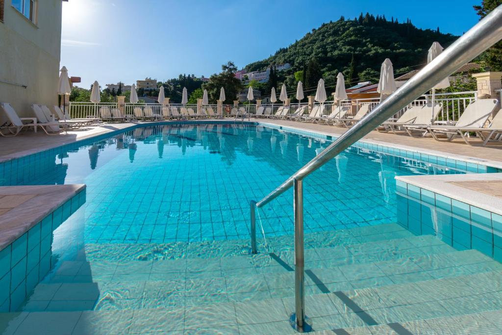 阿齐欧斯·贡多斯Angelica Hotel的一个带椅子和遮阳伞的大型蓝色游泳池