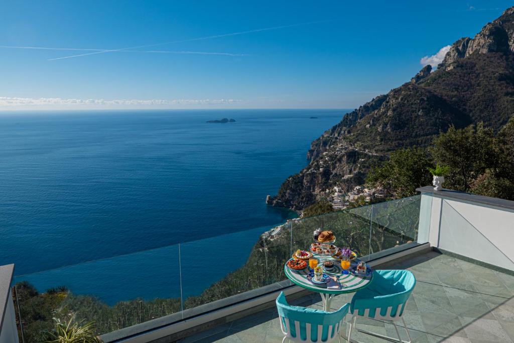 波西塔诺Petrea Lifestyle Suites的俯瞰大海的阳台配有桌椅