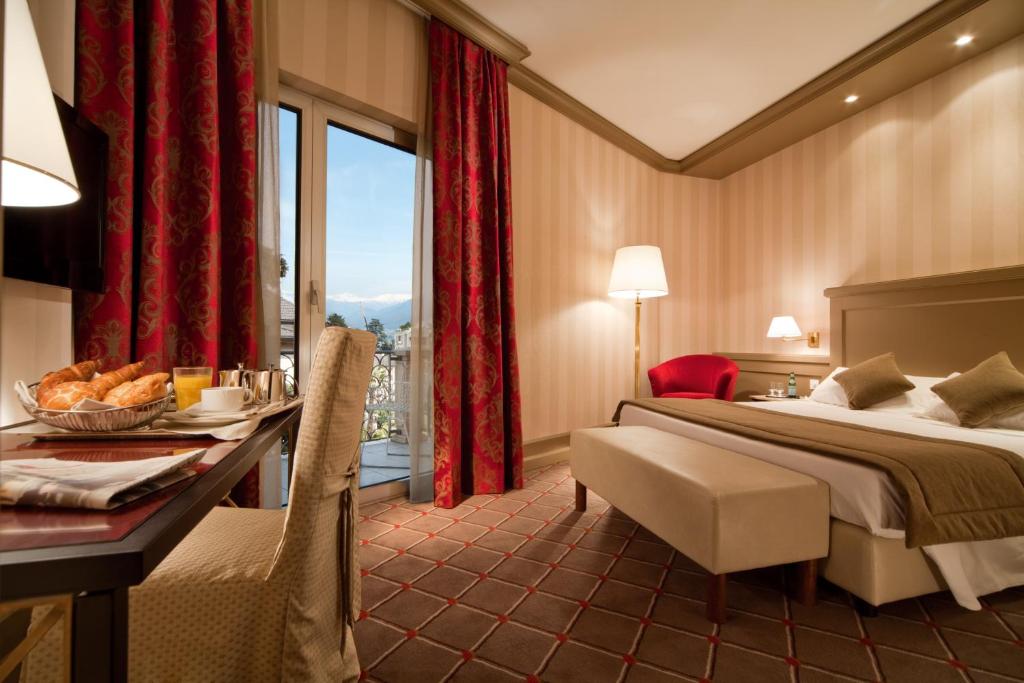卢加诺德拉帕斯酒店的酒店客房设有一张床、一张书桌和窗户。