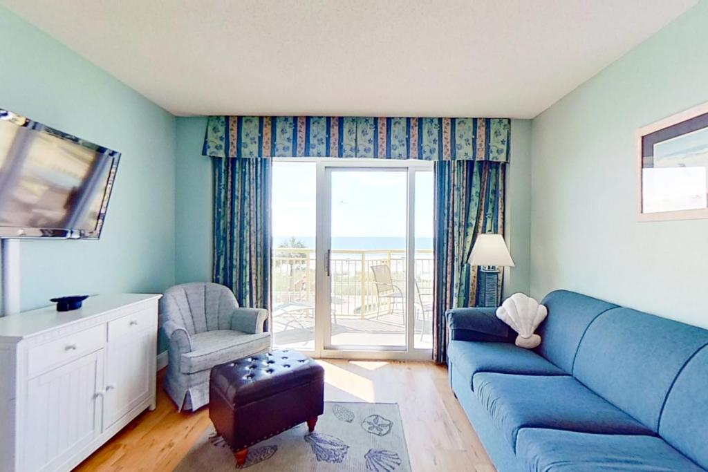 默特尔比奇Bay Watch 0232的客厅设有蓝色的沙发和窗户。