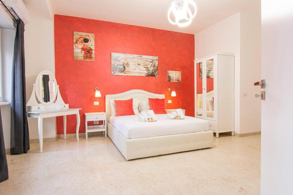 罗马Luxury Boutique Hotel的卧室配有白色的床和红色的墙壁