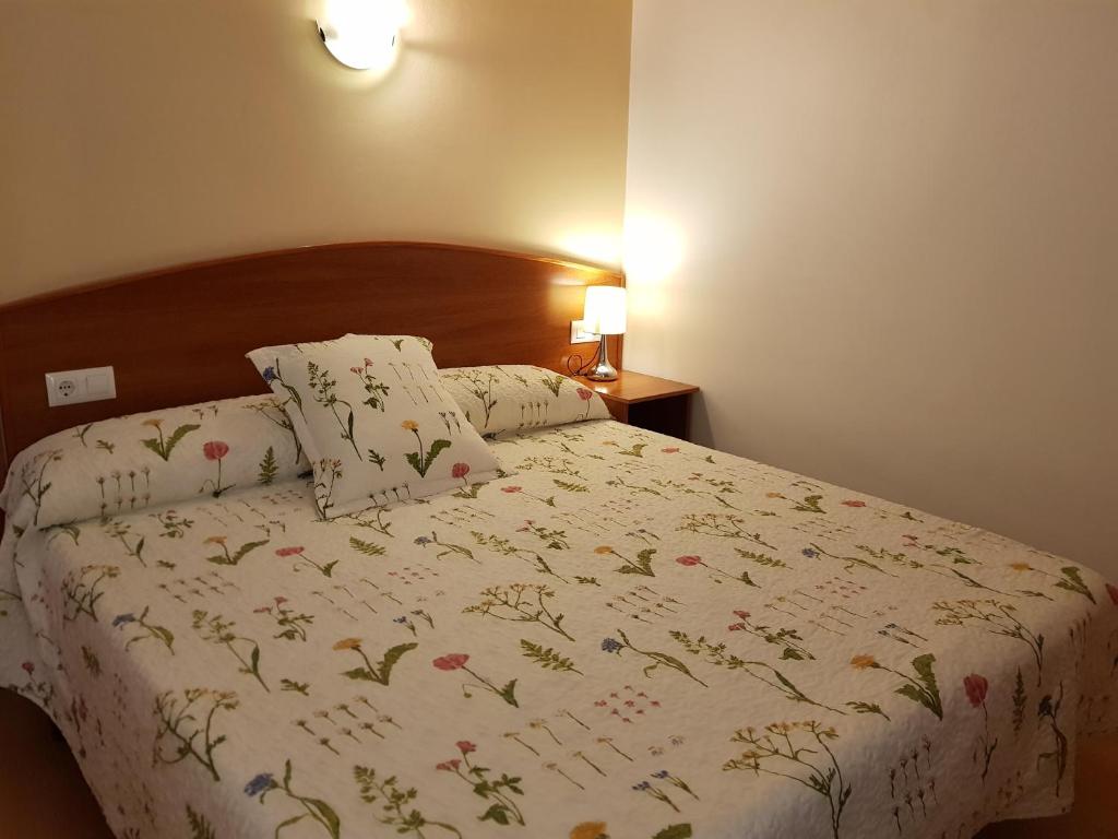 罗列特海岸玛丽旅馆 的一张带白色棉被和鲜花的床