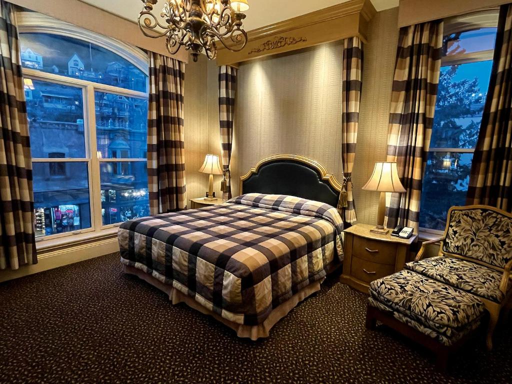 戴德伍德Celebrity Hotel的一间卧室配有一张床、一把椅子和窗户。