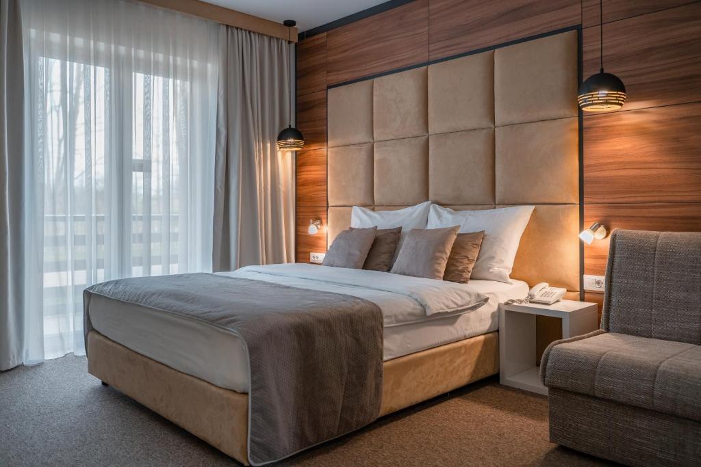 斯诺基米里亚娜及拉斯托克酒店的一间卧室配有一张大床和一把椅子