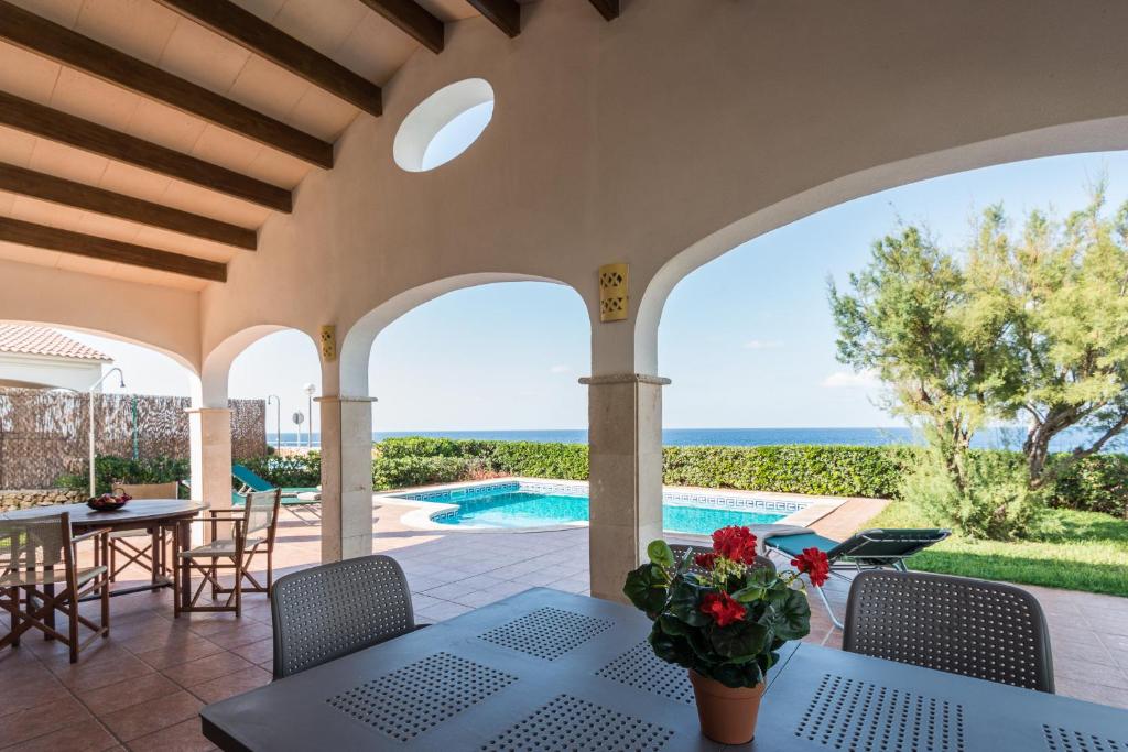 卡兰博希Villa Aldebaran的一个带桌椅的庭院和一个游泳池