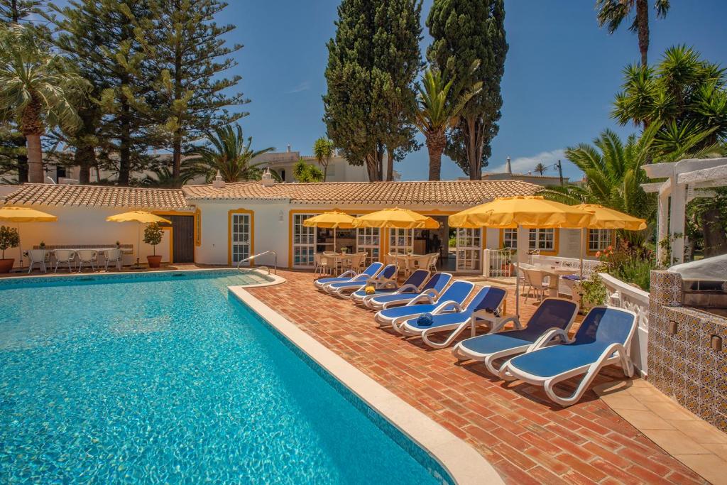 卢斯Quinta Paraiso da Mia - Two bedroom apartment的一个带躺椅和遮阳伞的游泳池