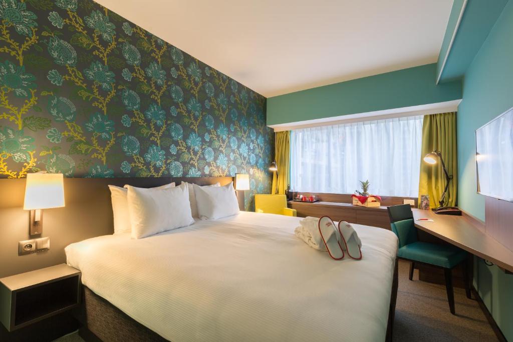 布鲁塞尔布鲁塞尔城市中心索恩酒店的酒店客房,配有一张带两张拖鞋的床