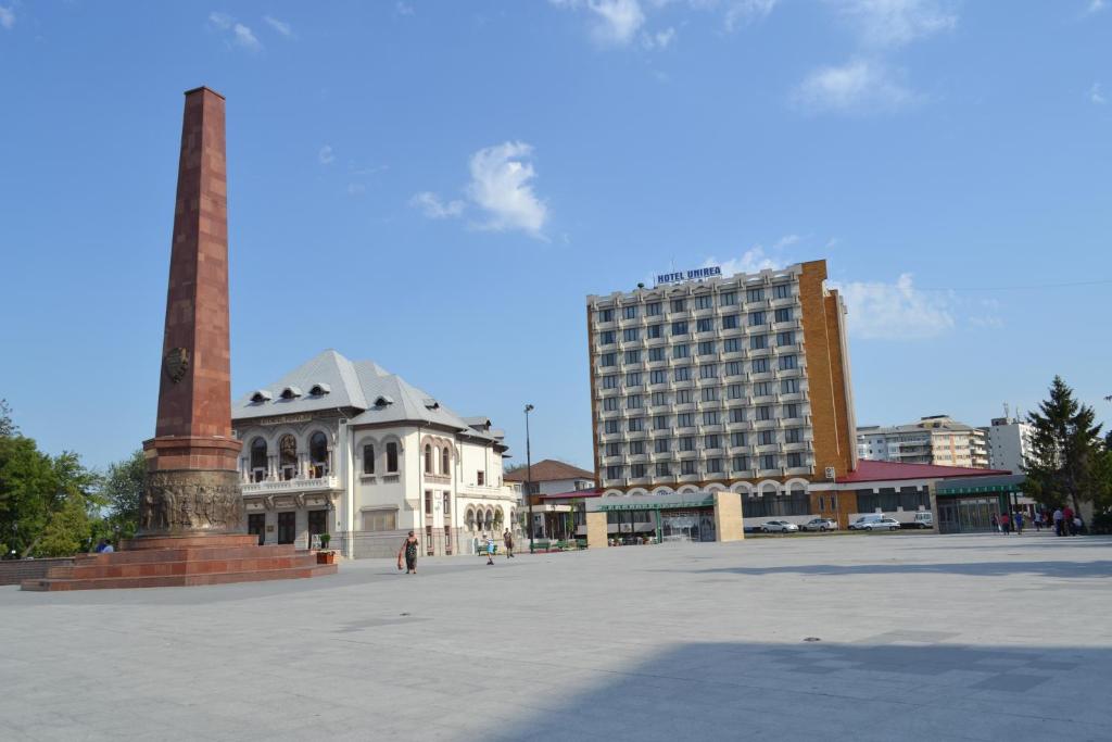 福克沙尼Hotel Unirea的一座城市广场,有一座高大的建筑和一座纪念碑
