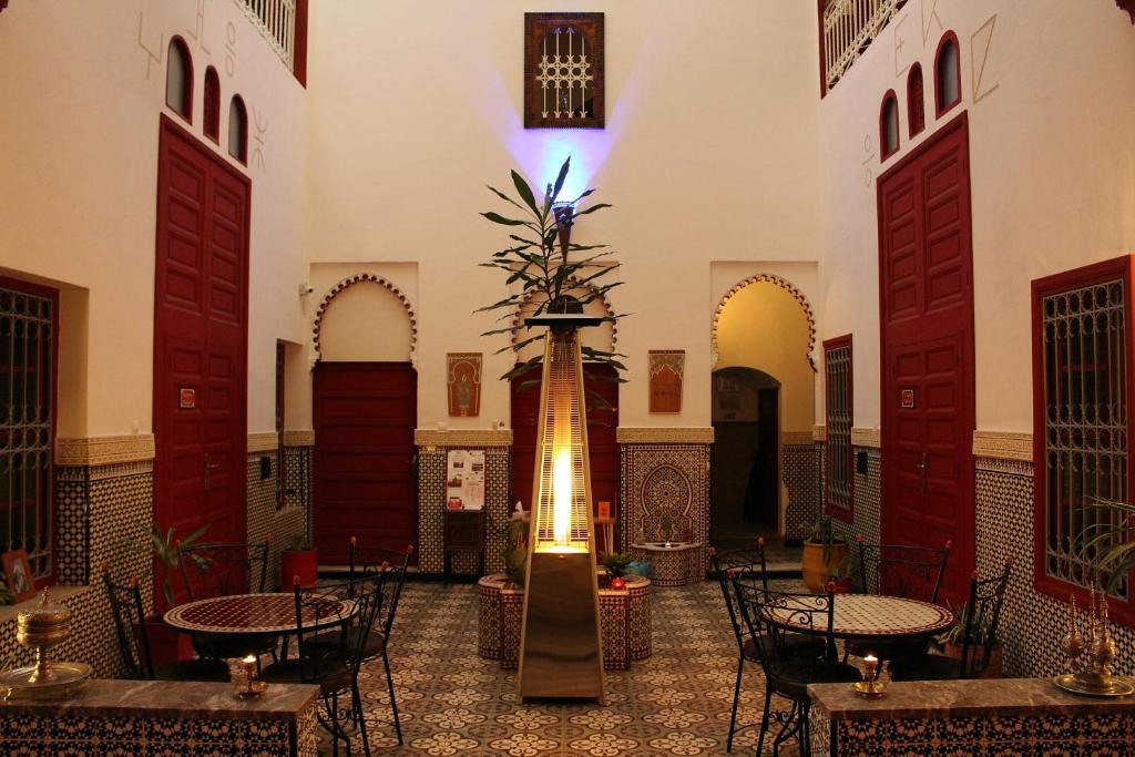 拉巴特梅塔哈摩洛哥传统庭院住宅旅馆的一间设有桌椅的房间和一个喷泉