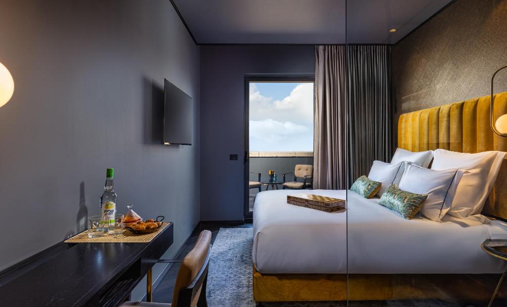 耶路撒冷Brown Machne Yehuda, a member of Brown Hotels的酒店客房设有一张床铺、一张桌子和一间用餐室。