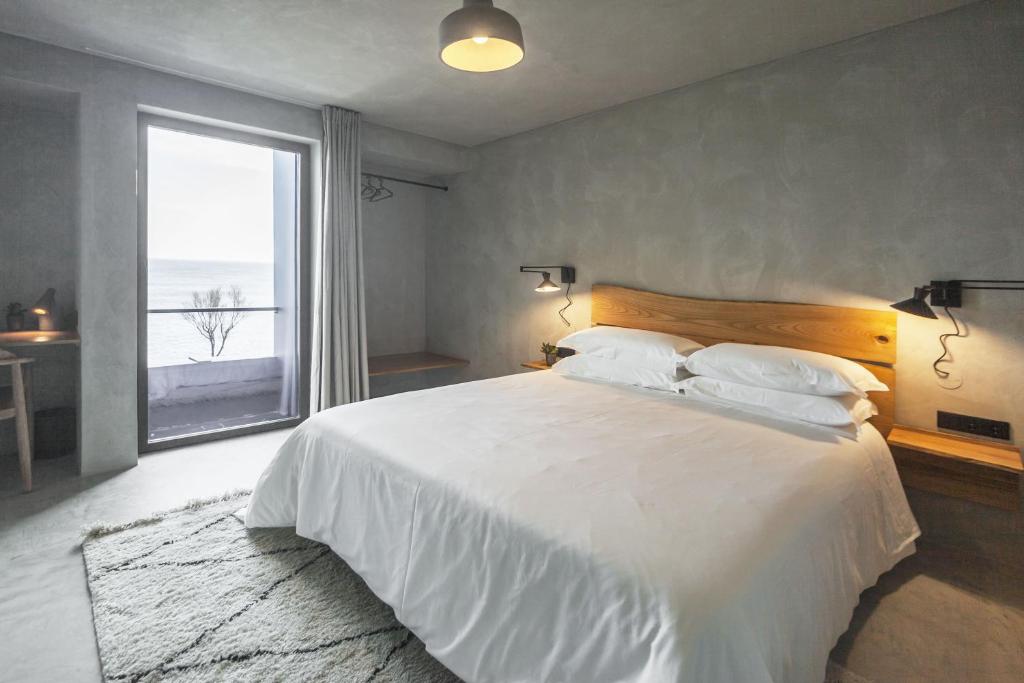 蓬塔德尔加达CASA DA ILHA - Slow Living Residence & Suites的卧室设有一张大白色的床和大窗户