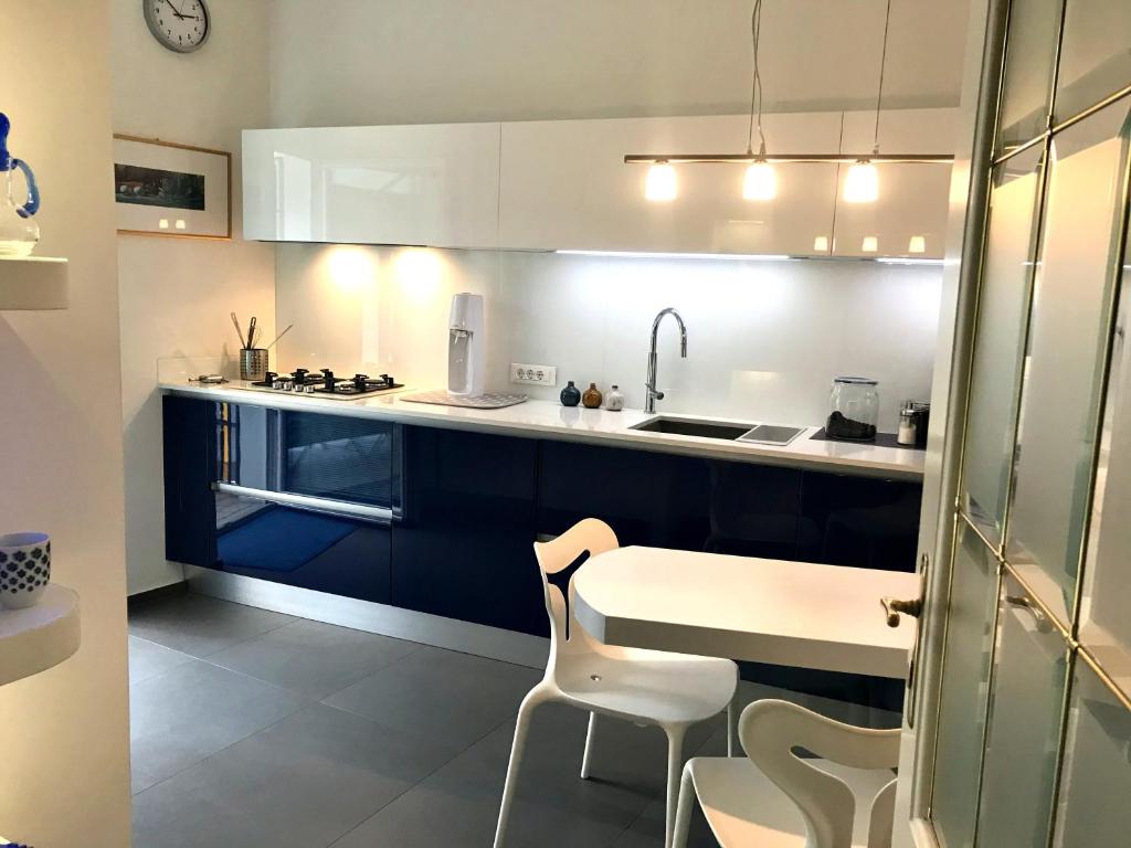 梅拉诺villa Mays的厨房配有蓝色和白色的橱柜以及桌椅