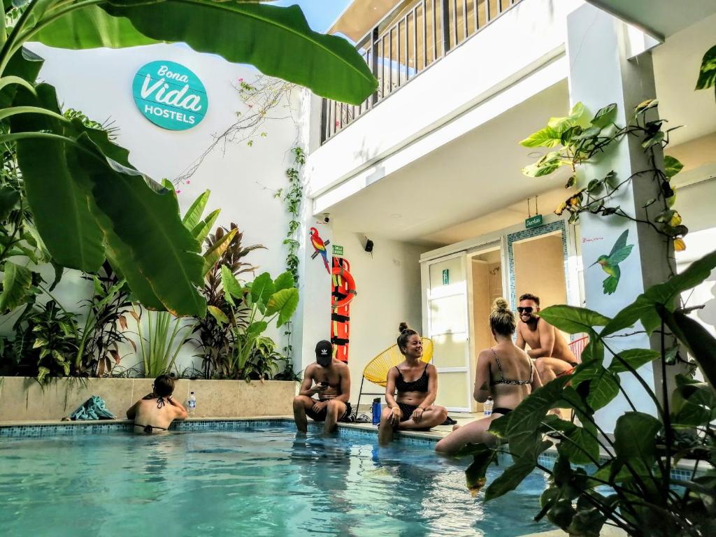 里奥阿查Bona Vida Hostel的一群坐在游泳池里的人