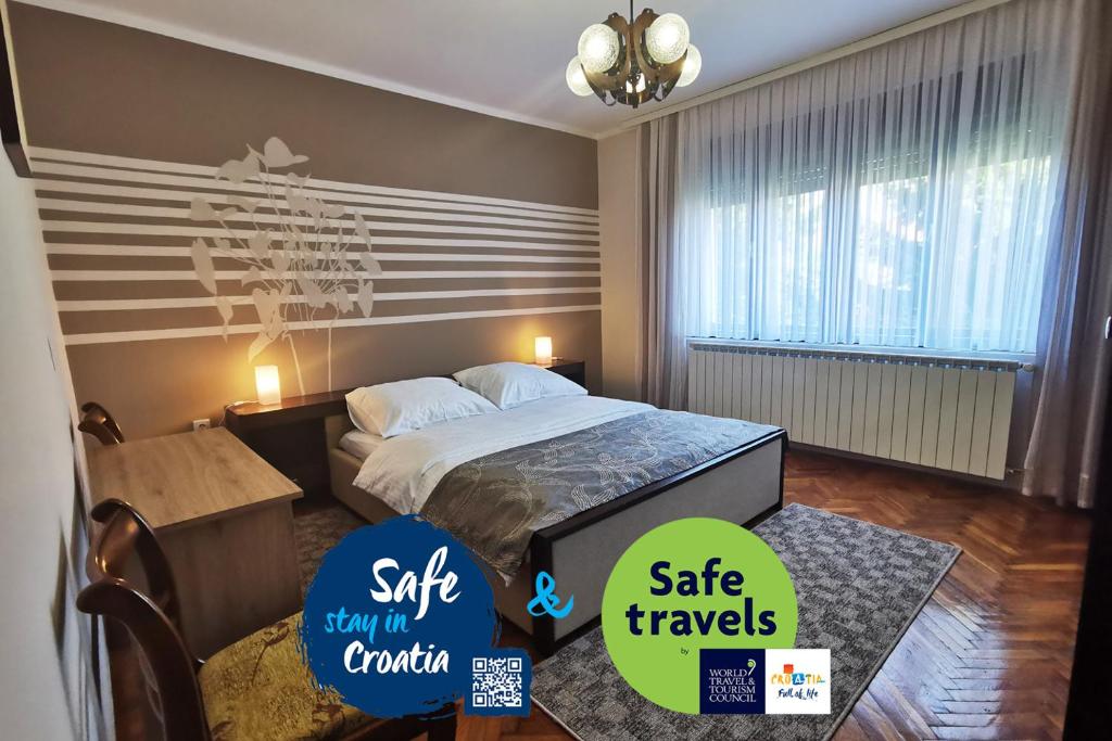 别洛瓦尔Apartman Škudar的酒店客房的墙上设有一张床和两张贴纸