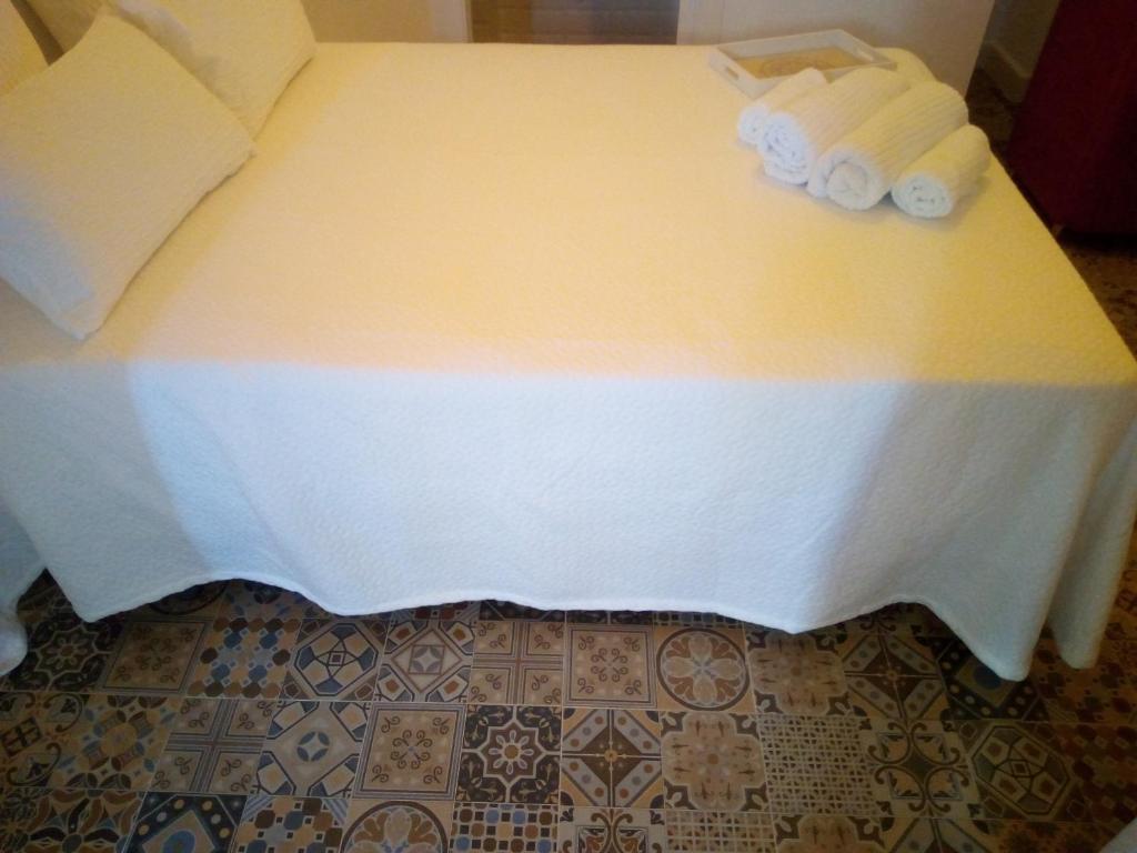 蓬塔翁布里亚VACACIONES DUQUE GALEY的一张带白色床单和2条滚毛巾的床