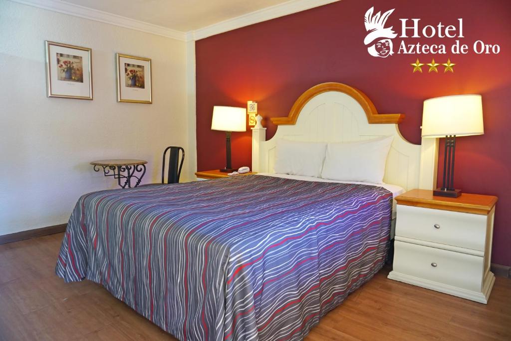 墨西卡利墨西卡利阿兹台克奥罗酒店的酒店客房带床,酒店带有美国死洋葱标志