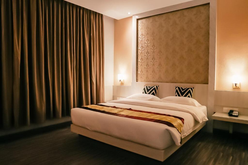 巴淡岛中心Grand Sydney Hotel的一间卧室,卧室内配有一张大床