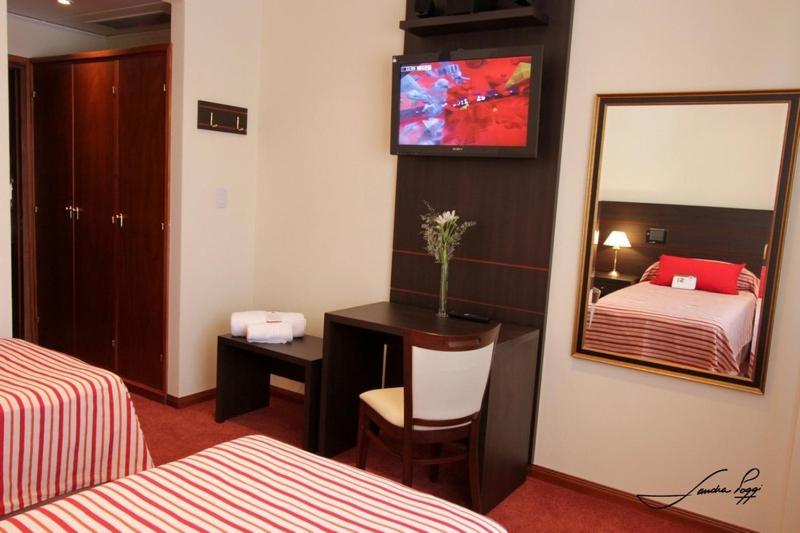 Nueve de JulioGrand Hotel Libertad的酒店客房,设有两张床和镜子