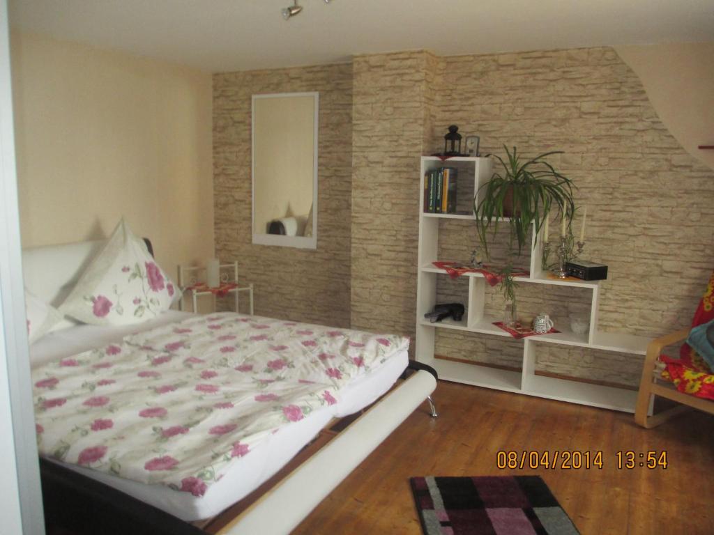 Waldesch祖格边姆民宿的一间卧室设有一张床和砖墙