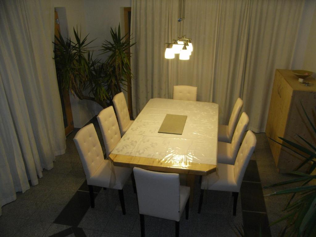 阿绍Apartment-Bergblick的餐桌、白色椅子和笔记本电脑