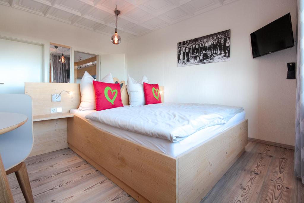 奥泊维森塔尔Haus am Berg - Pension direkt am Skihang的一间卧室配有一张带粉红色枕头的木床。