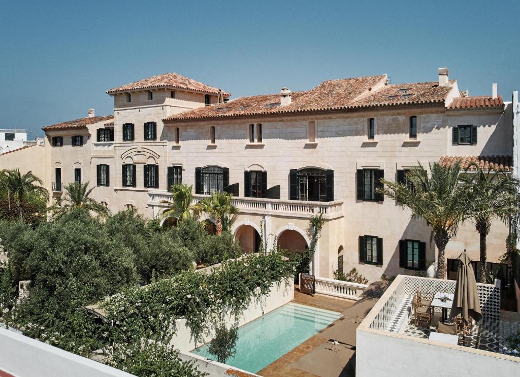 休达德亚Faustino Gran Relais & Chateaux的一座大房子,前面设有一个游泳池