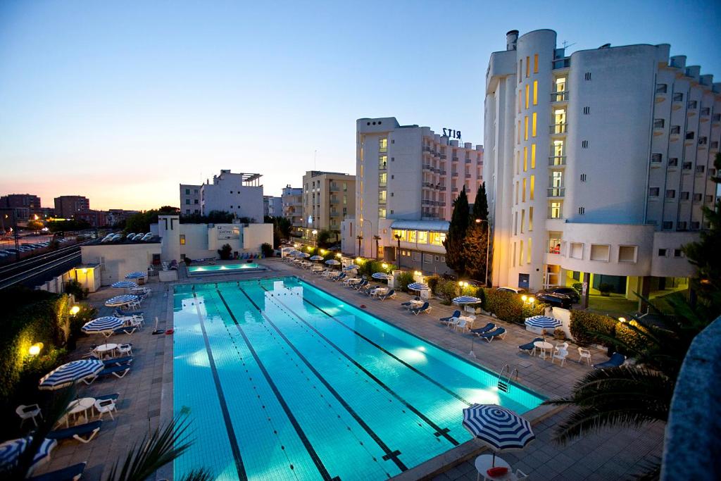 西尼加利亚HR Senigallia, già Hotel Ritz的一座游泳池,旁边设有椅子和遮阳伞