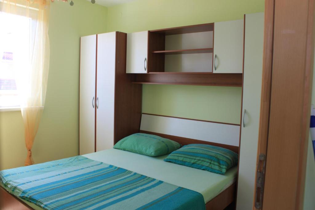 诺瓦利娅Summer house in Novalja的一间小卧室,配有床和书架